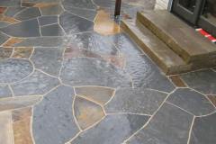Slate patio w/ sandstone steps.